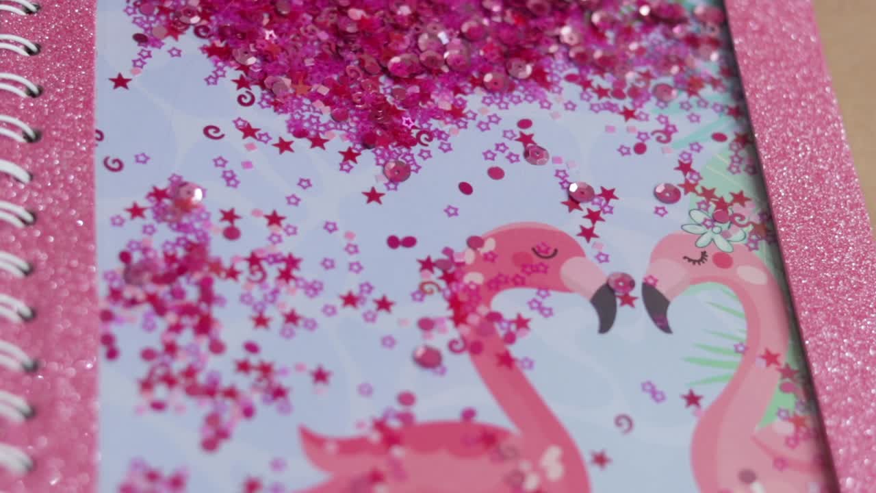 Copertina di un quaderno rosa personalizzato con paillettes e fenicotteri.
