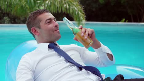 Businessman-lying-on-lilo-in-swimming-pool