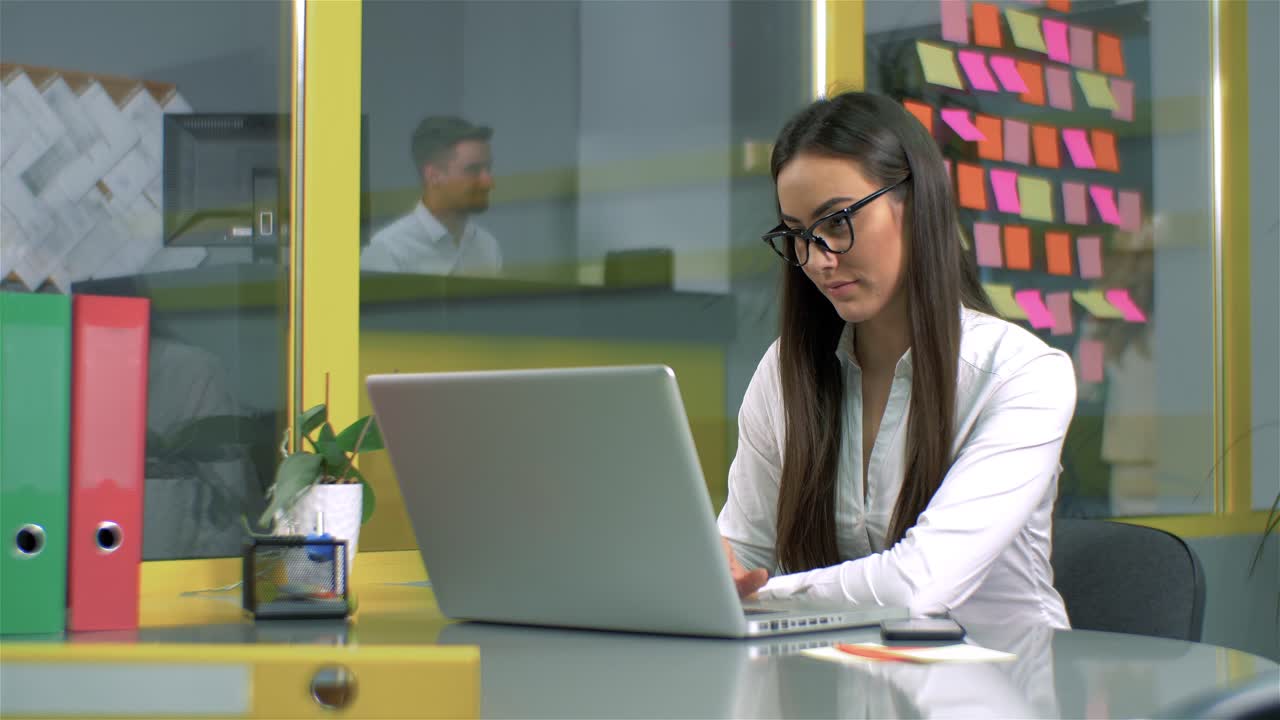 una mujer trabajando en una computadora portátil en una oficina