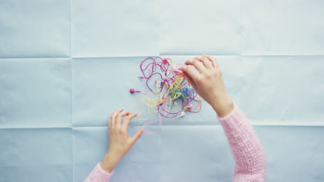 Top-view-hands-organising-tangled-multicolor-cables-desk-from-above---Red-Epic-Dragon