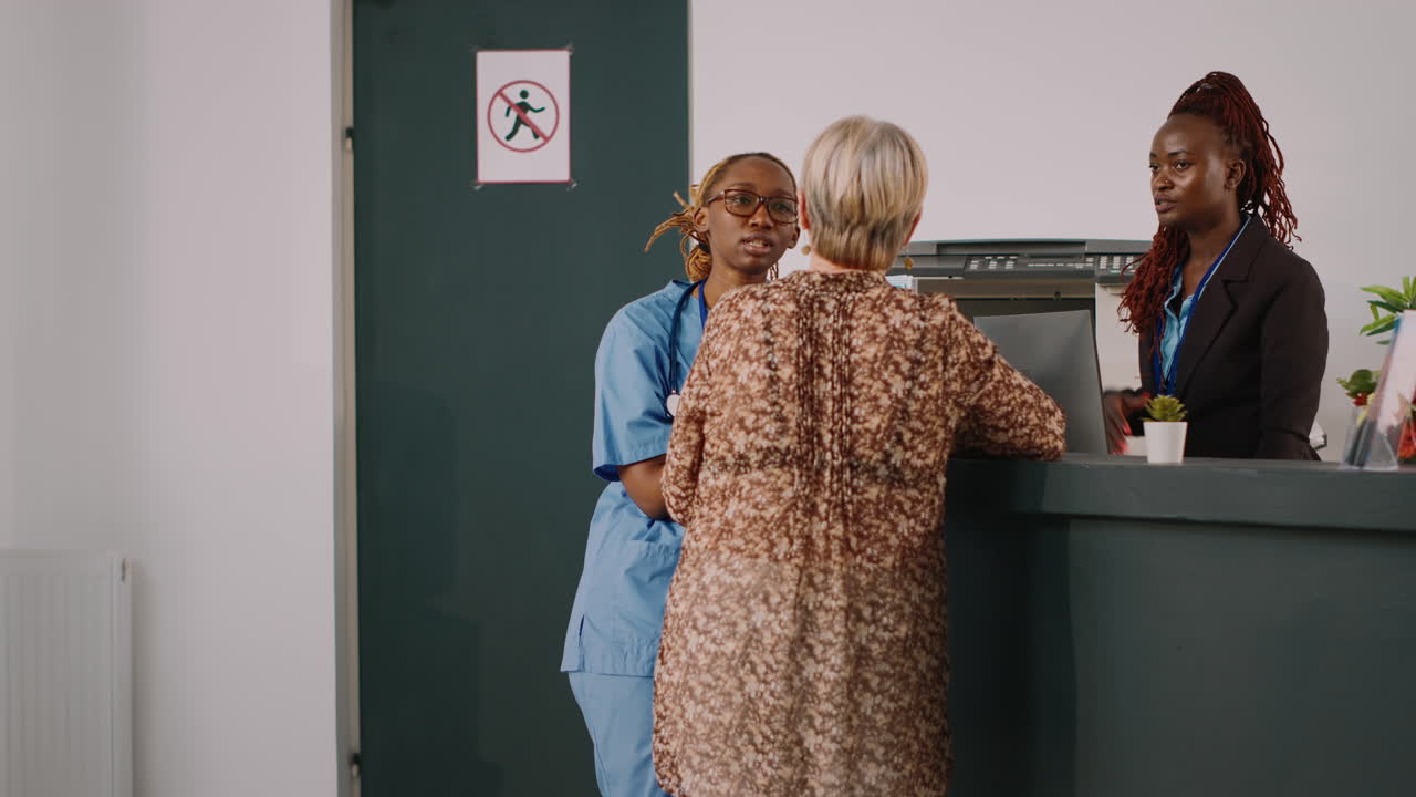 Team of medical workers talking at clinic reception counter