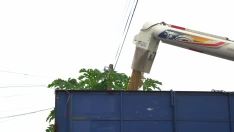 Combine-harvester-unloading-rice-crop-into-the-truck,-ready-to-be-transported-to-warehouse,-Douliu-city,-Yunlin-county,-Taiwan