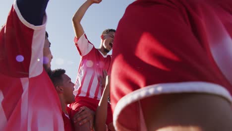 video of happy diverse group of male football players wining