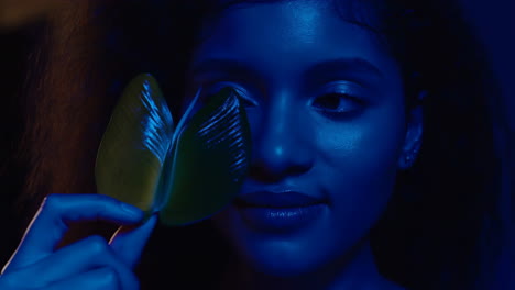 artistic portrait of a woman with blue light and leaf