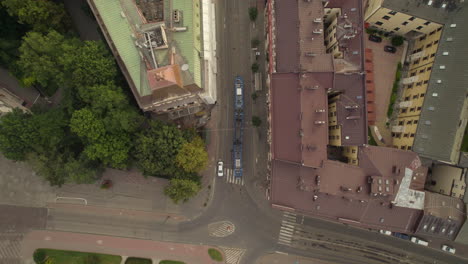 Tranvía-Girando-A-La-Vuelta-De-La-Esquina-En-El-Centro-De-Cracovia,-Polonia,-Vista-Aérea-De-Arriba-Hacia-Abajo