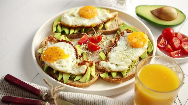 Delicious healthy breakfast with sliced avocado sandwiches with fried egg