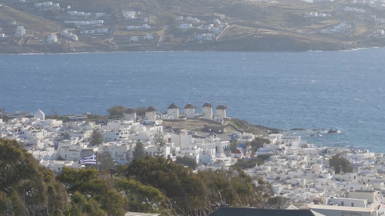 Mulini a vento iconici che si affacciano sugli edifici imbiancati a calce di Mykonos, Grecia