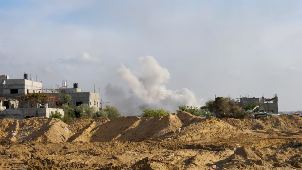 humo sobre un edificio demolido en llamas en la franja de gaza, estableciendo un disparo