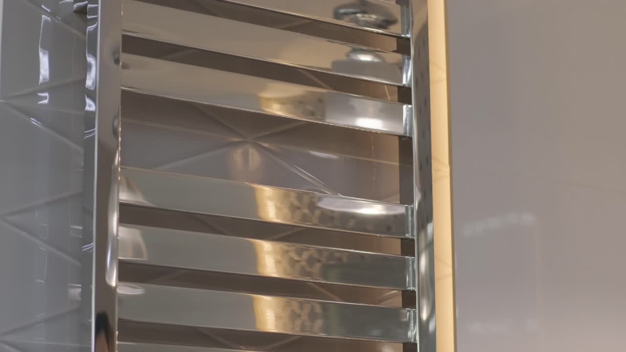 Mani di donna che rimuovono un asciugamano bianco dallo scaldasalviette in bagno