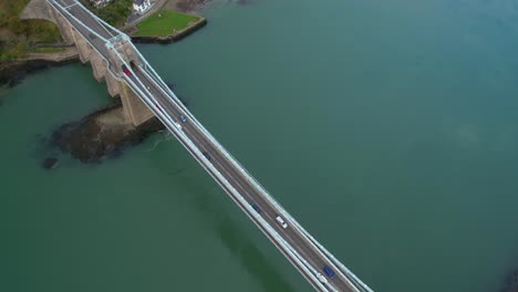 toma escénica de drones en el puente colgante de menai, cruce de autos, día nublado