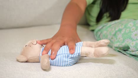 child with a teddy bear plush toy on a couch