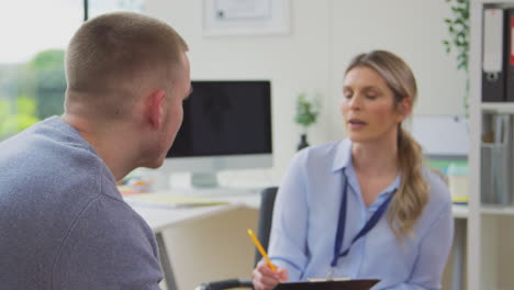 doctor talking to crying young male patient suffering with mental health problems