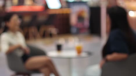 two people talking over drinks in a cafe
