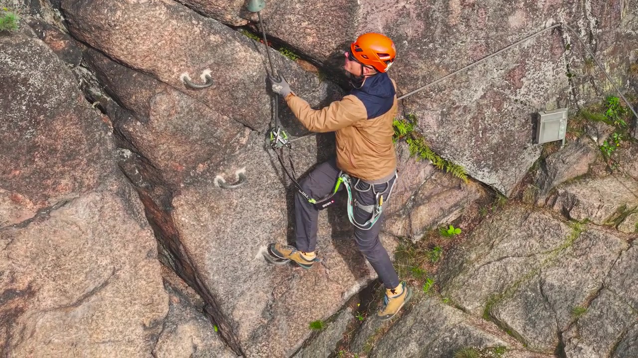 Rock climber use harness around waist and double trigger carabiner, Czechia