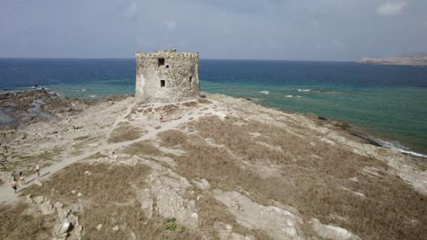 aerial fast approach to the la pelosa watchtower built in the xvi century on a small rocky island