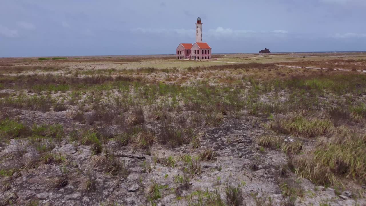 Fly towards Abandoned Light Tower by seashore aerial day exterior