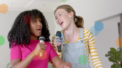 animation of coloured lights over happy diverse teenage girls with microphones singing at home