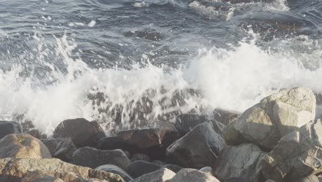 ocean waves break on big stone blocks in slowmotion and 4k at 25fps