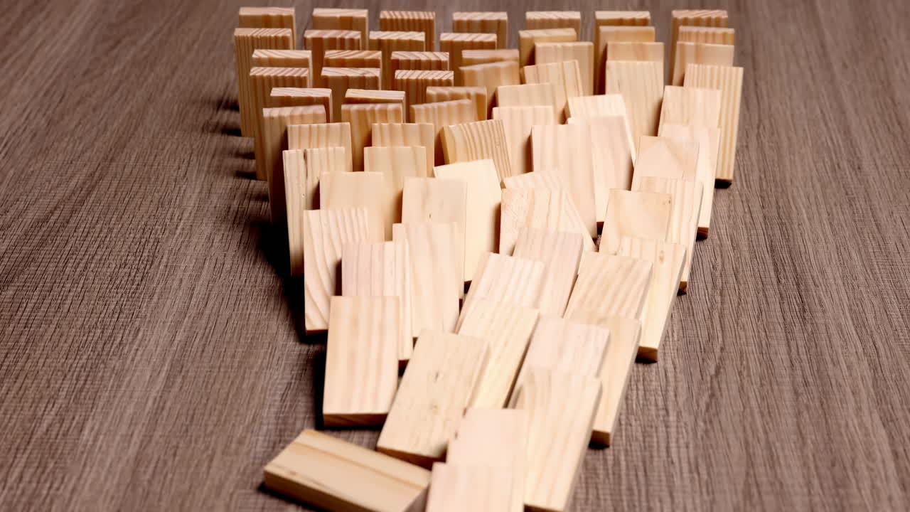 Effetto farfalla. Tessere di domino in legno che cadono in movimento: metafora di probabilità, futuro, possibilità e reazione a catena. Una potente metafora per l'energia potenziale, il concetto di opportunità, innovazione e nuovo inizio.