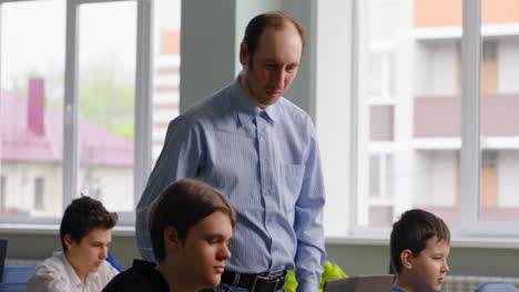 profesor ayudando a los estudiantes en una clase de computadora
