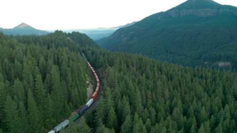 Aerial-shot-of-a-freight-train-rounding-a-corner-on-a-high-mountain-pass