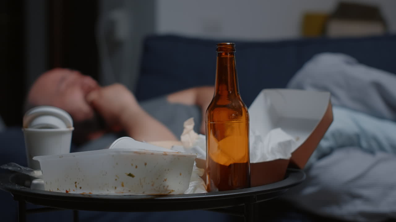 Close up of messy table with depressed man crying desperately in background