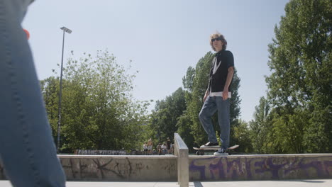 amigos caucásicos hablando de un truco en el parque de skate.