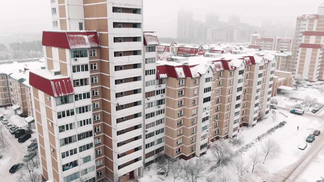 Заснеженный городской пейзаж с многоквартирными домами