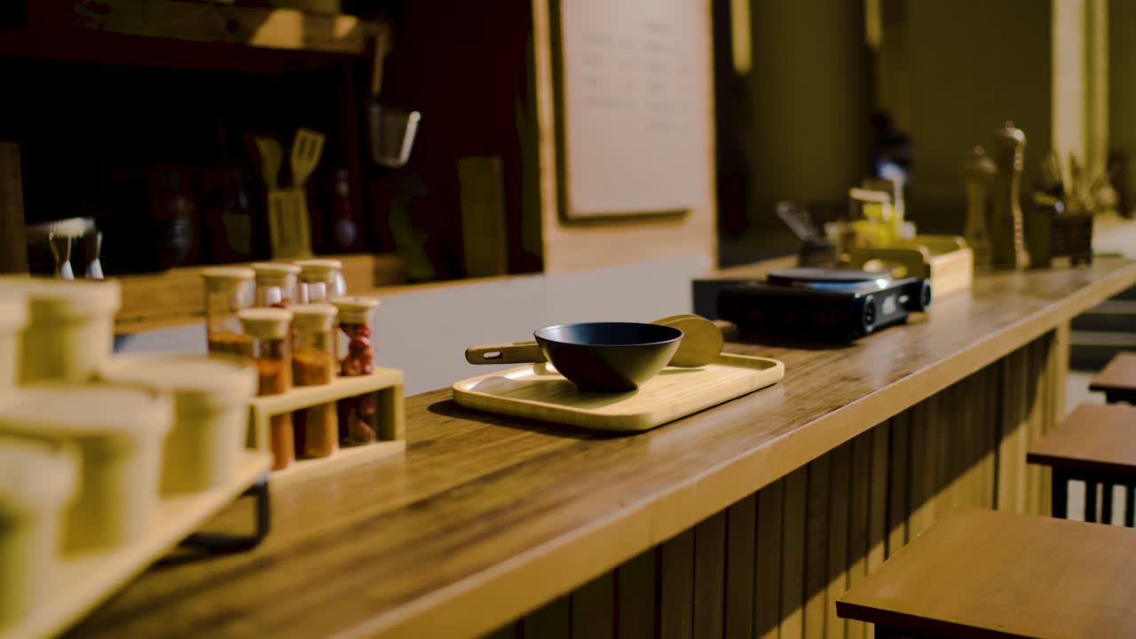 Coffee shop interior displaying wooden counter with bowls, spices, and seating area