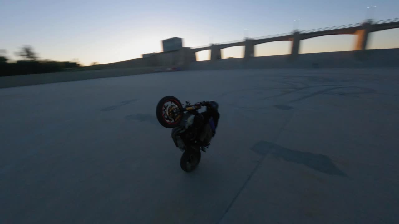 tehlikeli bir stunt yapan motosikletçinin üzerinde yörüngede dönen fpv çekimi