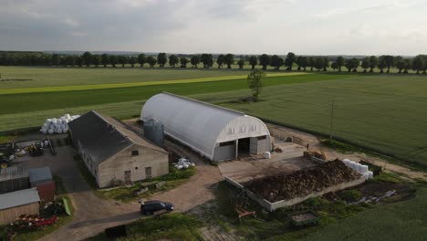 bird-pigeon-fly-around-white-arched-hall-on-farm-aerial-sunny-day