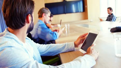 Executives-using-digital-tablet-in-conference-room