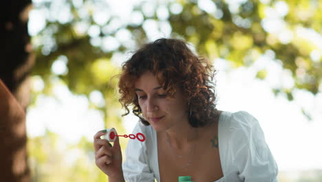 woman blowing bubbles outdoors