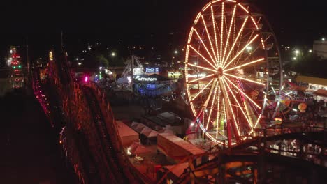 Klassische-Achterbahn-Und-Grand-Wheel-Auf-Der-Washington-State-Fair-In-Der-Nacht-In-Puyallup,-Washington,-USA