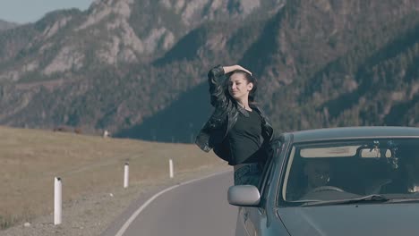 woman raises hand to sky holds leather jacket and relaxes