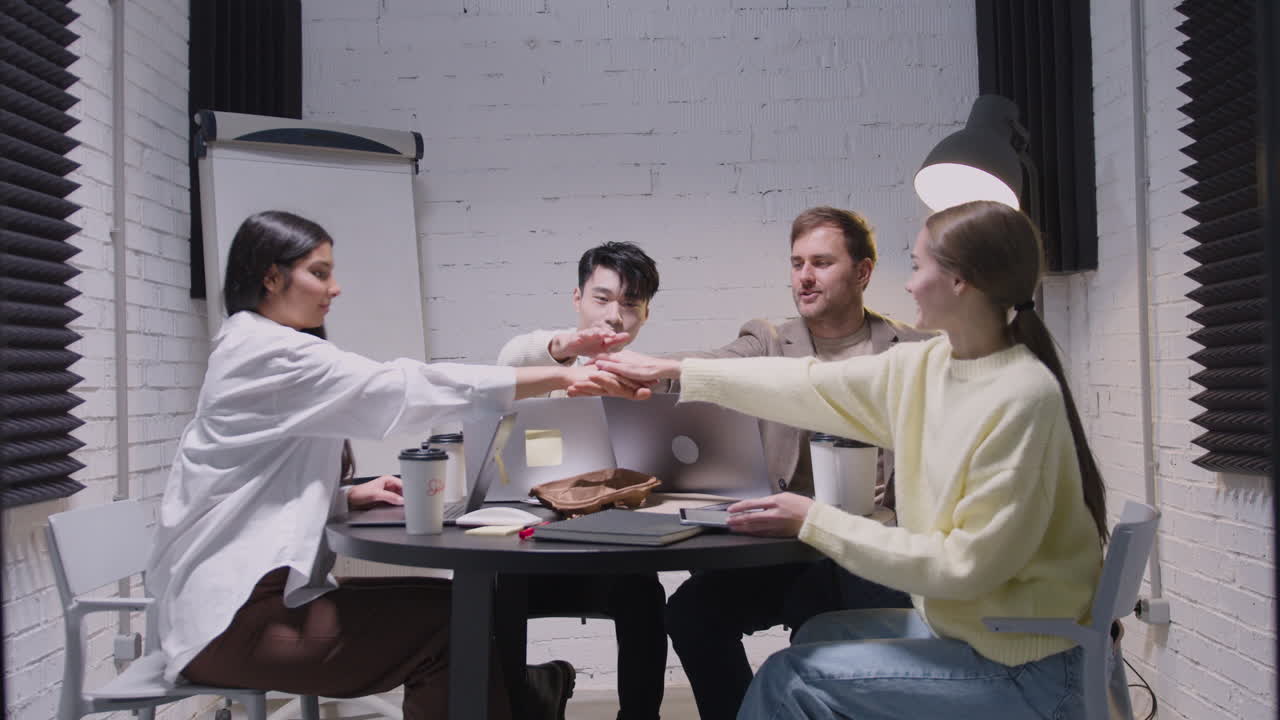 팀 회의에서 함께 손을 잡고 다민족 행복한 직원 그룹