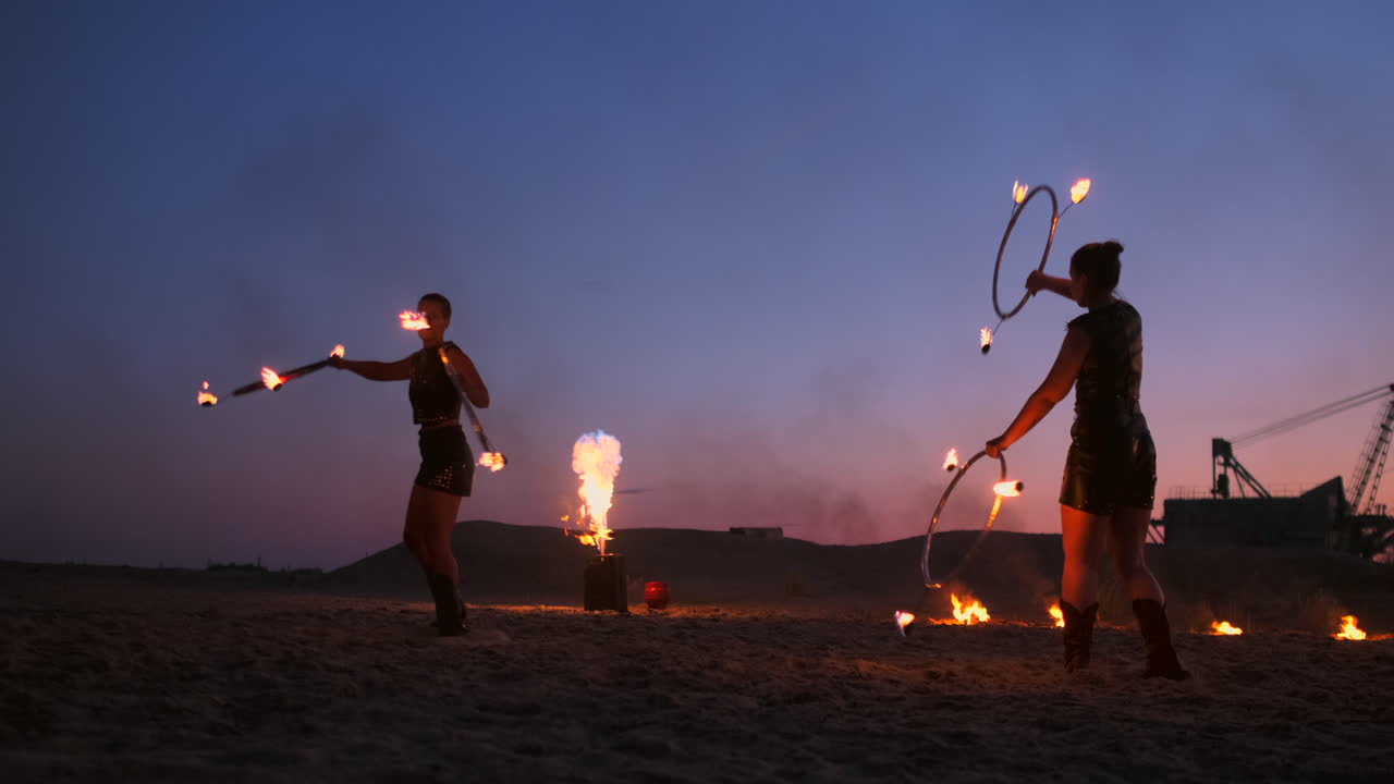 espectáculo de fuego. un grupo de artistas profesionales realiza una variedad de instalaciones de fuego. niños y niñas realizaron bailes con fuego en la noche en la calle en el parque