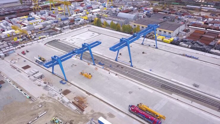 Industrial Site with Cranes and Rail Tracks