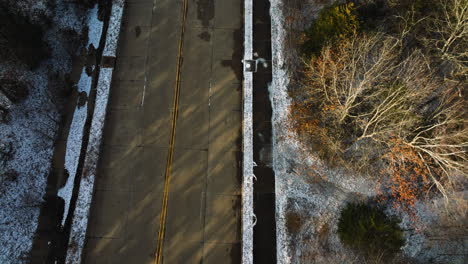 Empty-road-on-Mount-Sequoyah,-snow-dusted-trees-lining,-aerial-shot-in-winter,-late-afternoon-light