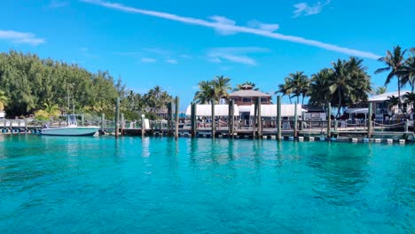 llegando a la isla de la laguna azul en las bahamas en barco 4k 30 fps toma panorámica tranquila de una magnífica isla clave con casas y árboles, agua de color turquesa