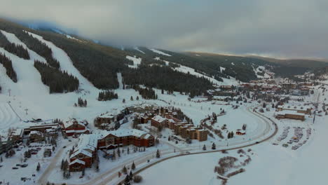 foggy cloud layer winter snowy early morning sunrise aerial drone copper mountain colorado ski resort village eagle flyer super bee lift ikon epic pass cars on road snowboarding tubing ski forward pan