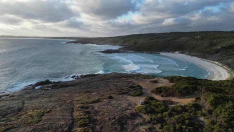 bremer beach with reaching waves of ocean during cloudy sunset in australia