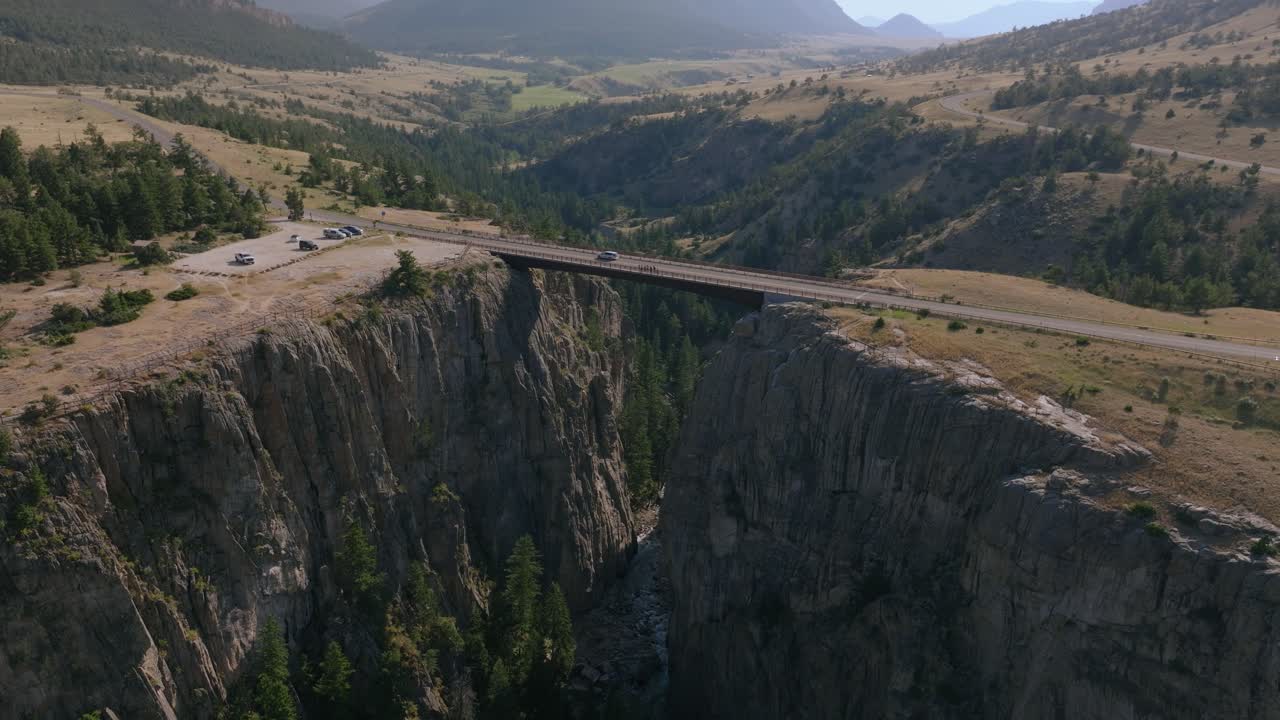 Aerial View of a Bridge Over a Deep Canyon with River and Mountains