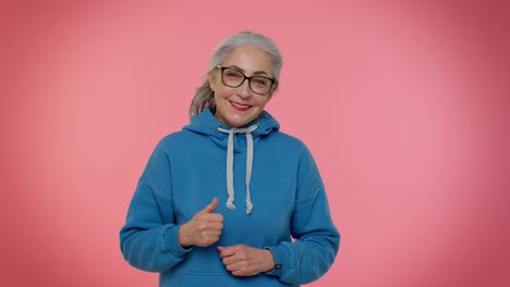 senior old granny woman raises thumbs up agrees with something or gives positive reply likes good