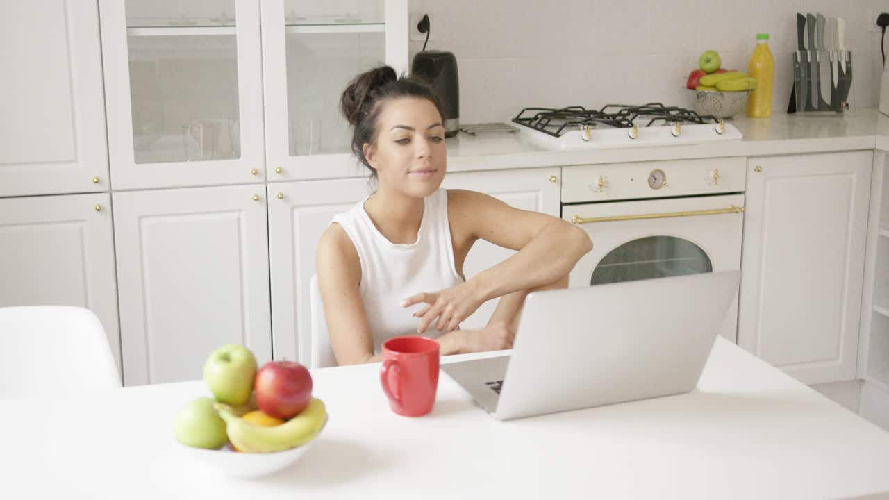 mujer joven usando laptop en casa