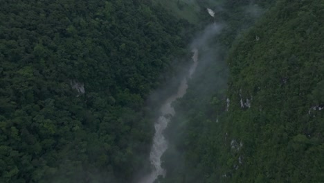 Tilt-up-shot-of-Cahabon-river-in-jungle-of-Guatemala-during-cloudy-day,-aerial