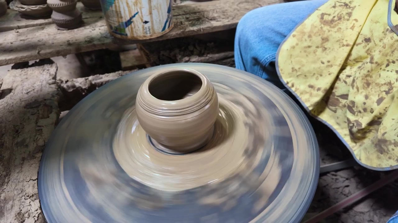 Primo piano di mani che modellano un vaso di ceramica su un tornio a Nonthaburi, Thailandia.