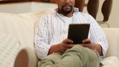 man using digital tablet in living room 4k