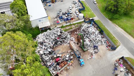 aerial view of scrapyard with moving machinery