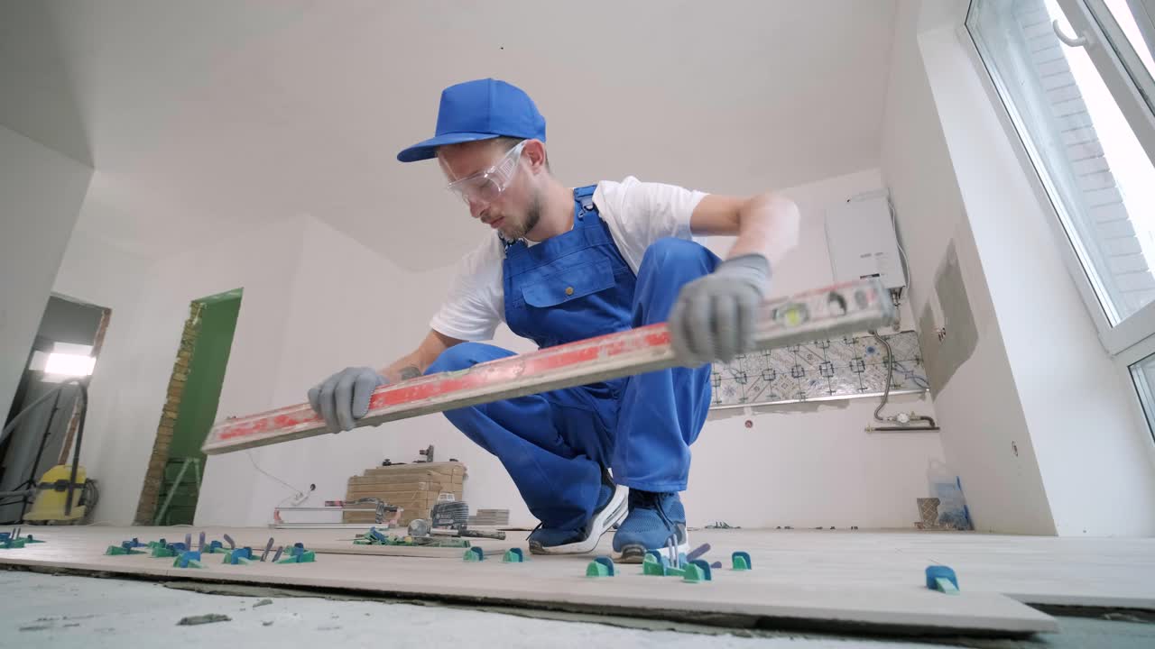 Construction, renovation, repair apartment. Installing ceramic floor tiles - measuring and cutting the pieces. Cuts tile. Tile cutting